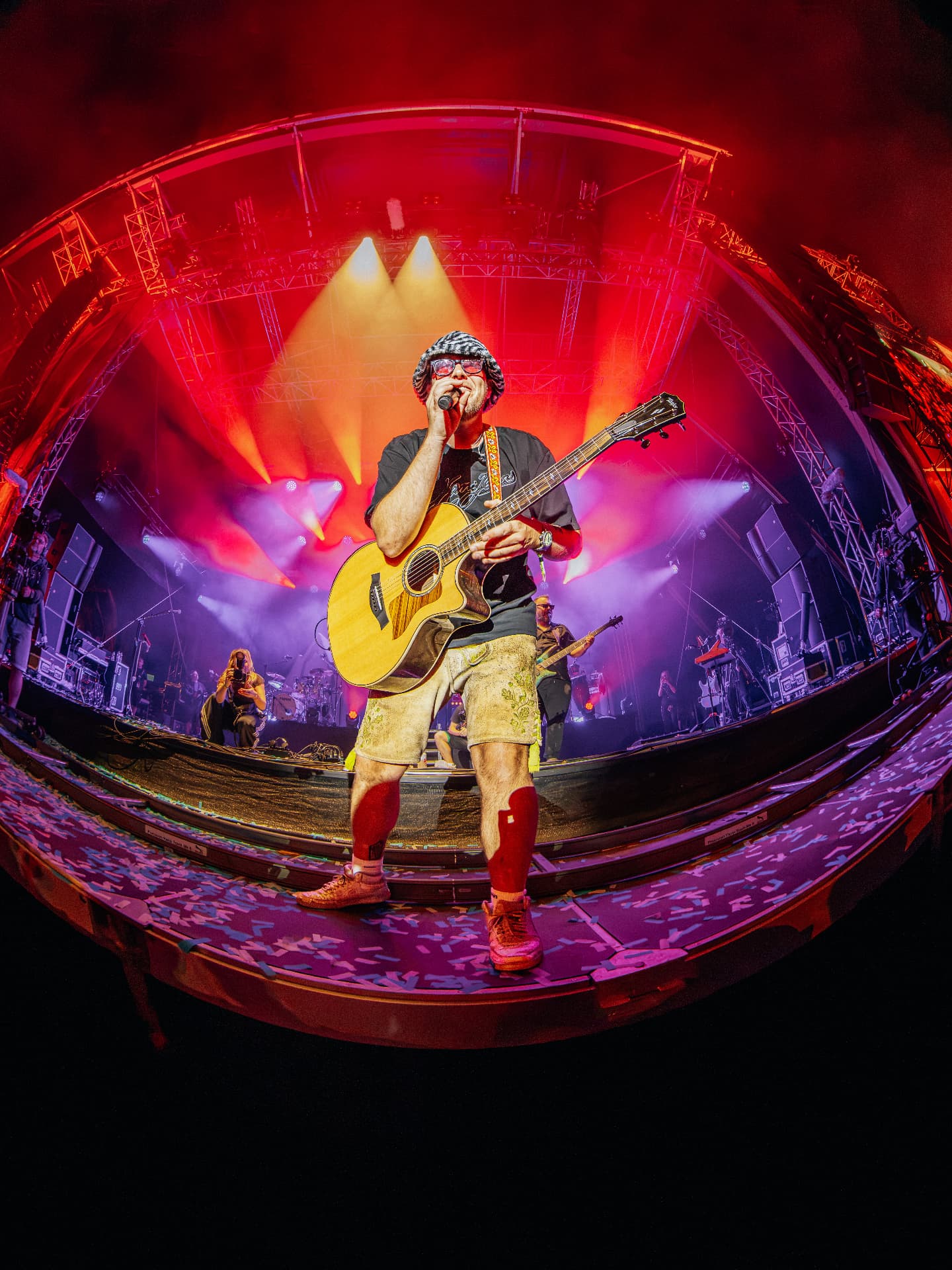 Singer with acoustic guitar on a festival stage shot on a fisheye lens, concert photography by Paul Rumplmaier